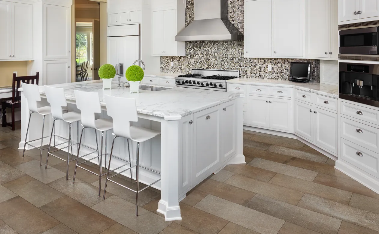 white cabinets and glass tile backsplash with stone marble countertops in kitchen with wood look floors